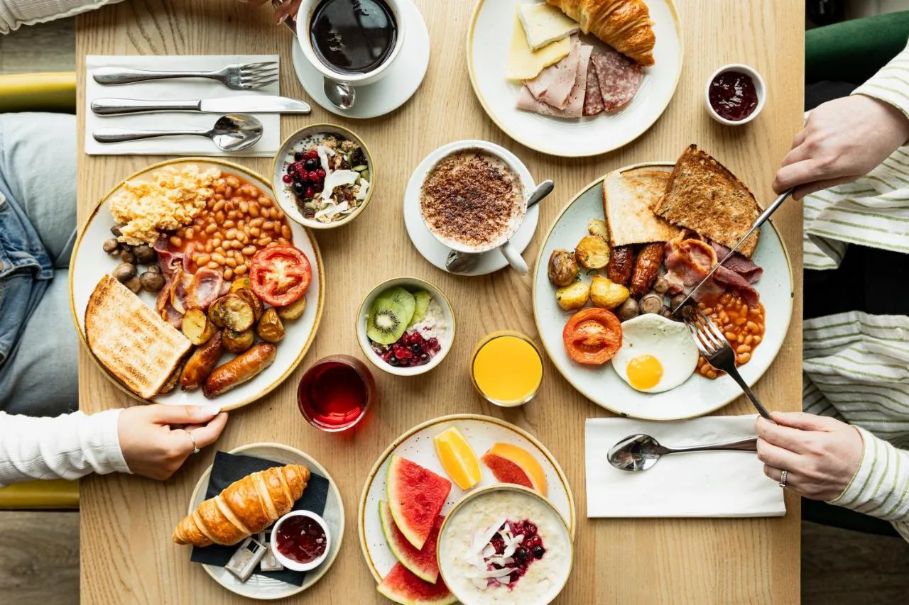 a table with plates of breakfast food on it at Leonardo Hotel Aberdeen in Aberdeen